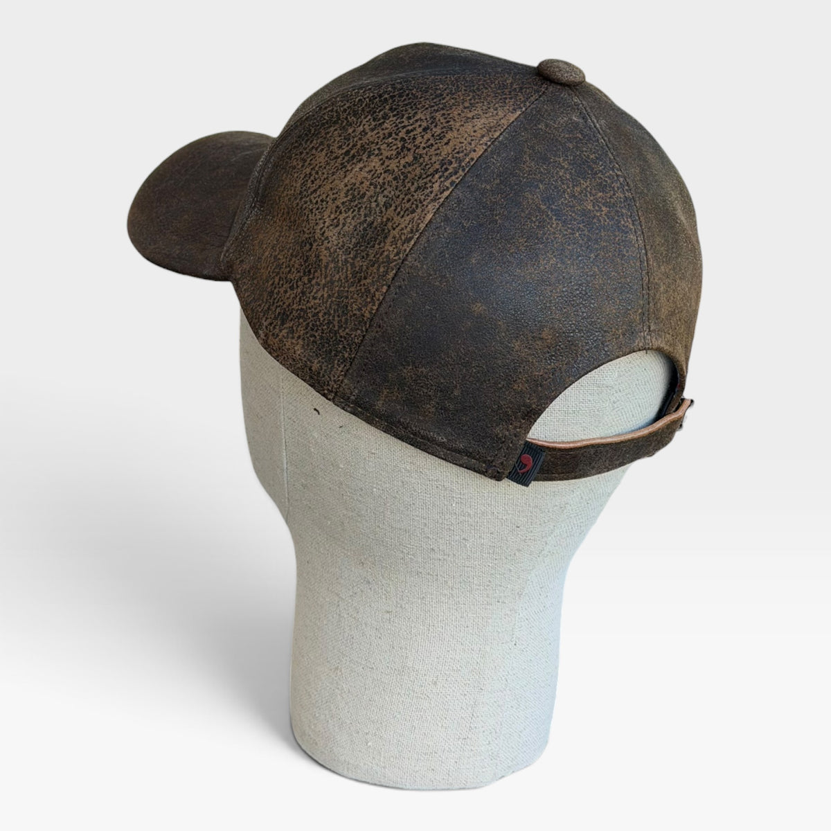Cappellino baseball in pelle marrone visto da dietro con cinturino regolabile