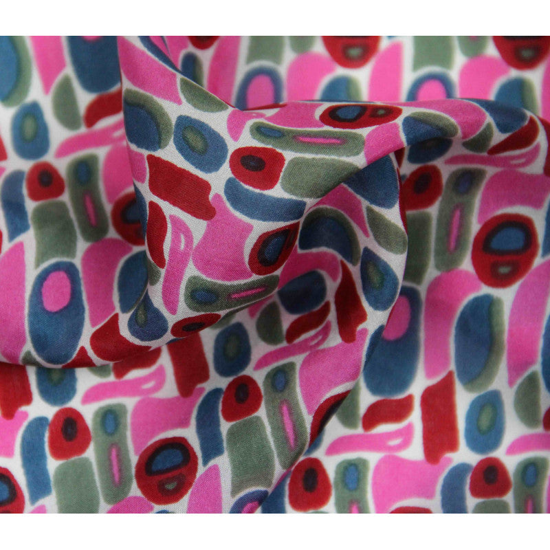 Dettaglio tessuto seta con motivo artistico nei toni rosa, rosso, verde e blu